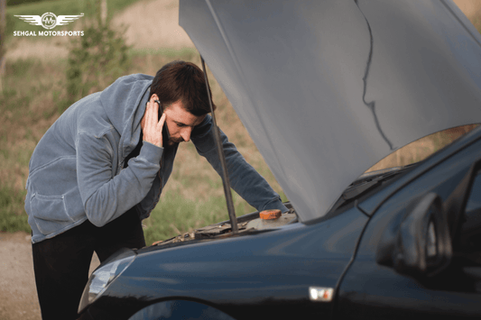 man calling beside broken car